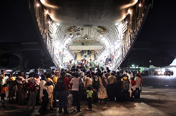 Аэропорт Порт-о-Пренс, Гаити. Посадка пассажиров на грузовой самолет американских ВВС, улетающий во Флориду.