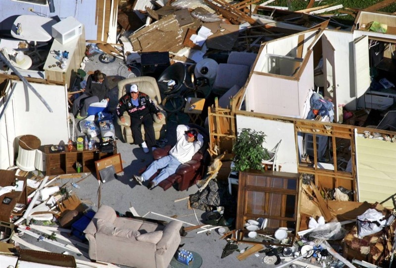 Мужчины сидят в разрушенном передвижном домике в Форт-Лодердейле, Филадельфия, 25 октября 2005, после урагана Вилма, пронесшегося через весь штат приблизительно за семь часов. Убытки, причиненные ураганом, составили $21,5 миллиарда. (Wilfredo Lee/AP)