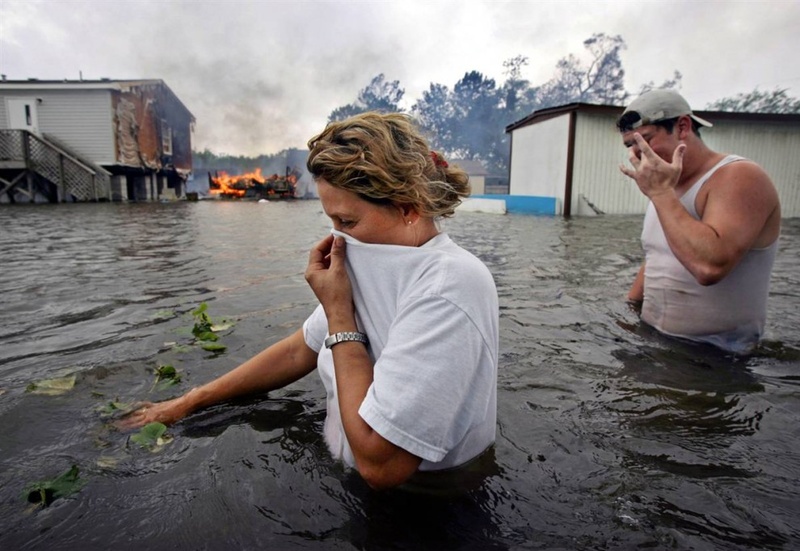 Жителям города Лафит, Луизиана, 24 сентября 2005 года пришлось иметь дело с затоплением и огнем - последствиями урагана Рита, проходившего через этот регион. Ураган причинил ущерб на сумму в $11,8 миллиардов в штатах Луизиана, Техас и Флорида. (Kevork Djansezian/AP)