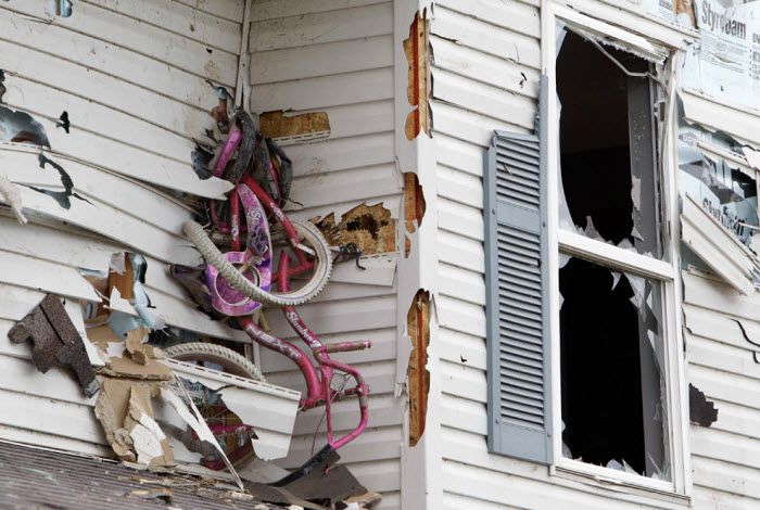 Торнадо, обрушившийся на Милбери в штате Огайо, с такой силой ударил этот детский велосипед о стену дома, что велосипед там так и остался висеть, 6 июня 2010 года. (AP Photo/Paul Sancya)