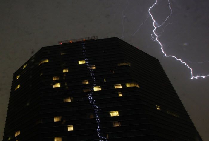 Вспышка молнии отражается в здании отеля «Hilton» во время урагана в Мехико, Мексика, 23 мая 2010 года. (REUTERS/Daniel Aguilar)