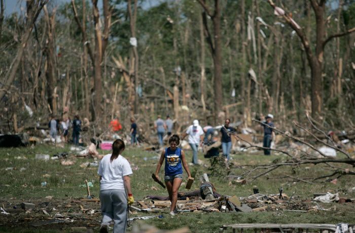Добровольцы убирают с поля мусор, принесённый сюда торнадо, который уничтожил по меньшей мере 50 домов в Милбери, Огайо. (AP Photo/J.D. Pooley)