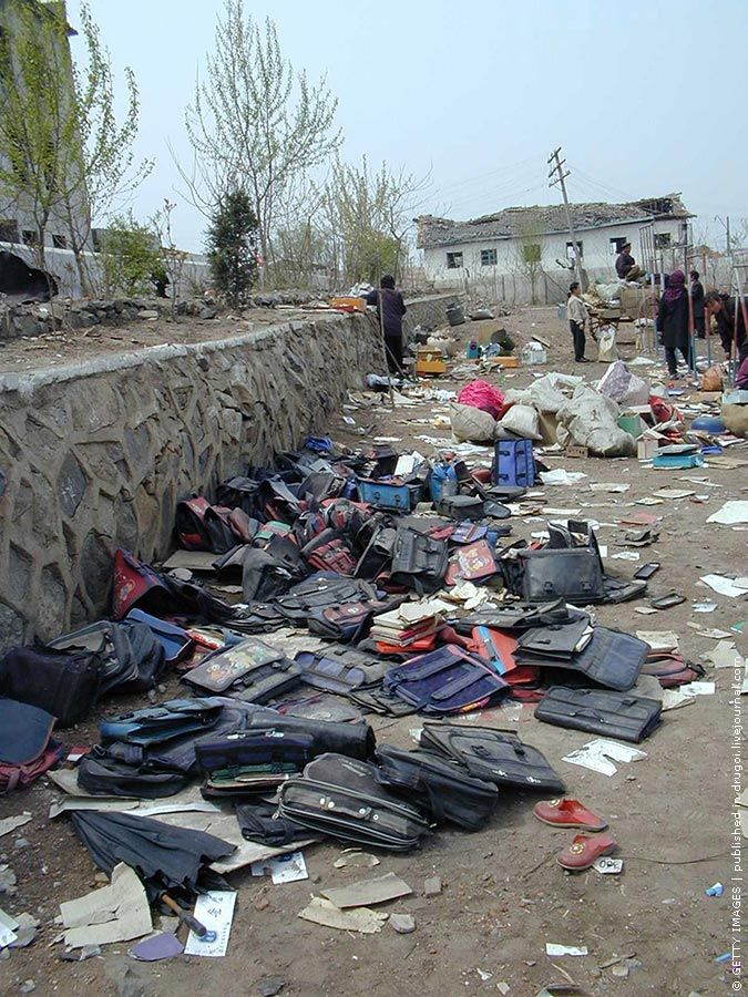 Детские портфели рядом с разрушенным зданием школы. Всего по разным данным погибло от 130 до 170 человек, несколько тысяч были ранены.