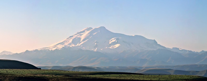 Эльбрус – Двуглавый Эльбрус, высочайшая точка России и Европы, находится на стыке границ Кабардино-Балкарии и Карачаево-Черкесии. Западная вершина Эльбруса возвышается над уровнем моря на 5642 метра, восточная – на 5621 метр. Вершины разделены глубокой седловиной. Эльбрус находится в нескольких километрах к северу от Главного Кавказского хребта и соединяется с ним хребтом-перемычкой.