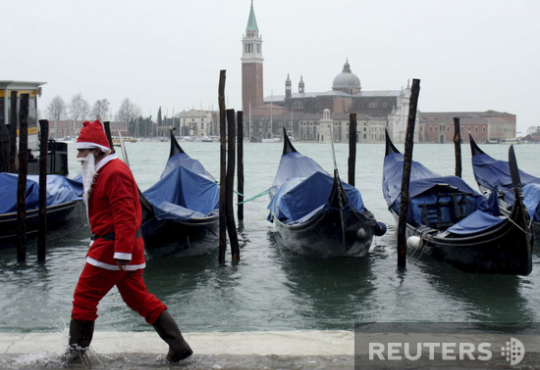 Венеция, Италия. Санта-Клаус демонстрирует навыки ходьбы по воде