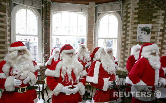Учащиеся лондонской школы Санта-Клаусов выполняют упражнения, продемонстрированные учителем на уроке Санта-смеха