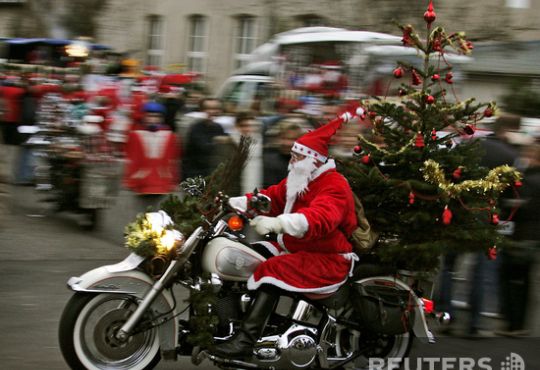 Участник парада Санта-Клаусов в Бранденбурге, Германия, прихватил с собой живую ель