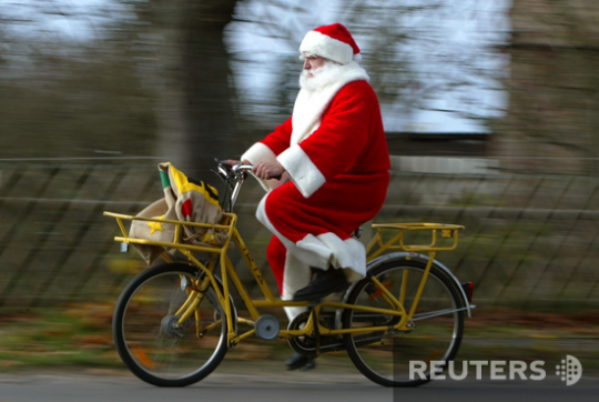 Санта-велосипедист катит по улицам Гиммельпфорта, Германия